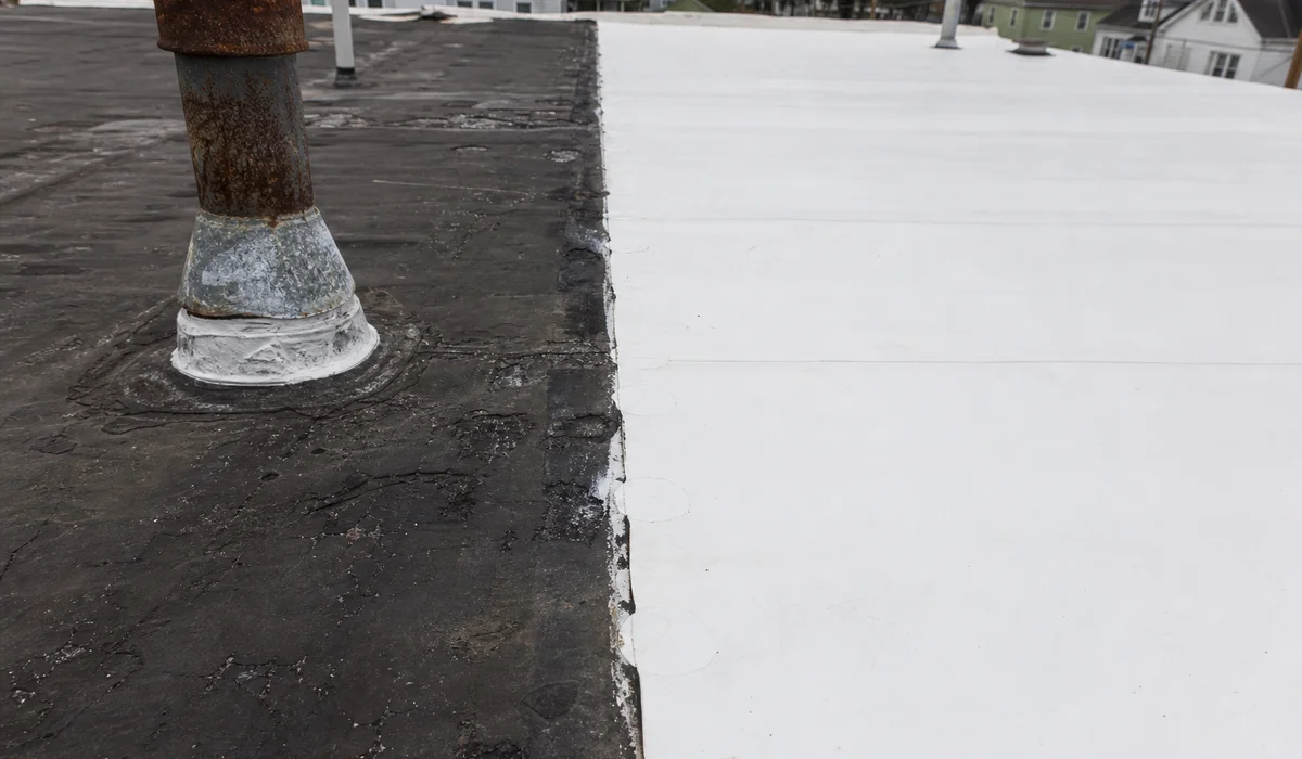 Aging flat roof next to newly installed membrane