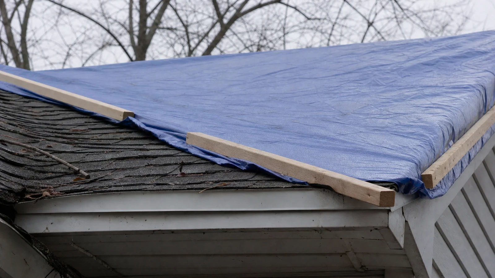 Emergency tarp secured over damaged roof section