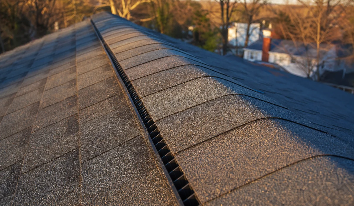 Newly installed continuous ridge vent along a roof peak