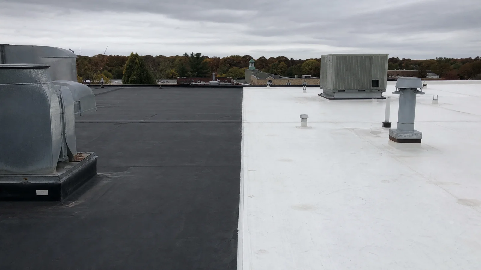Black EPDM membrane and white TPO membrane installed on adjacent flat roof sections